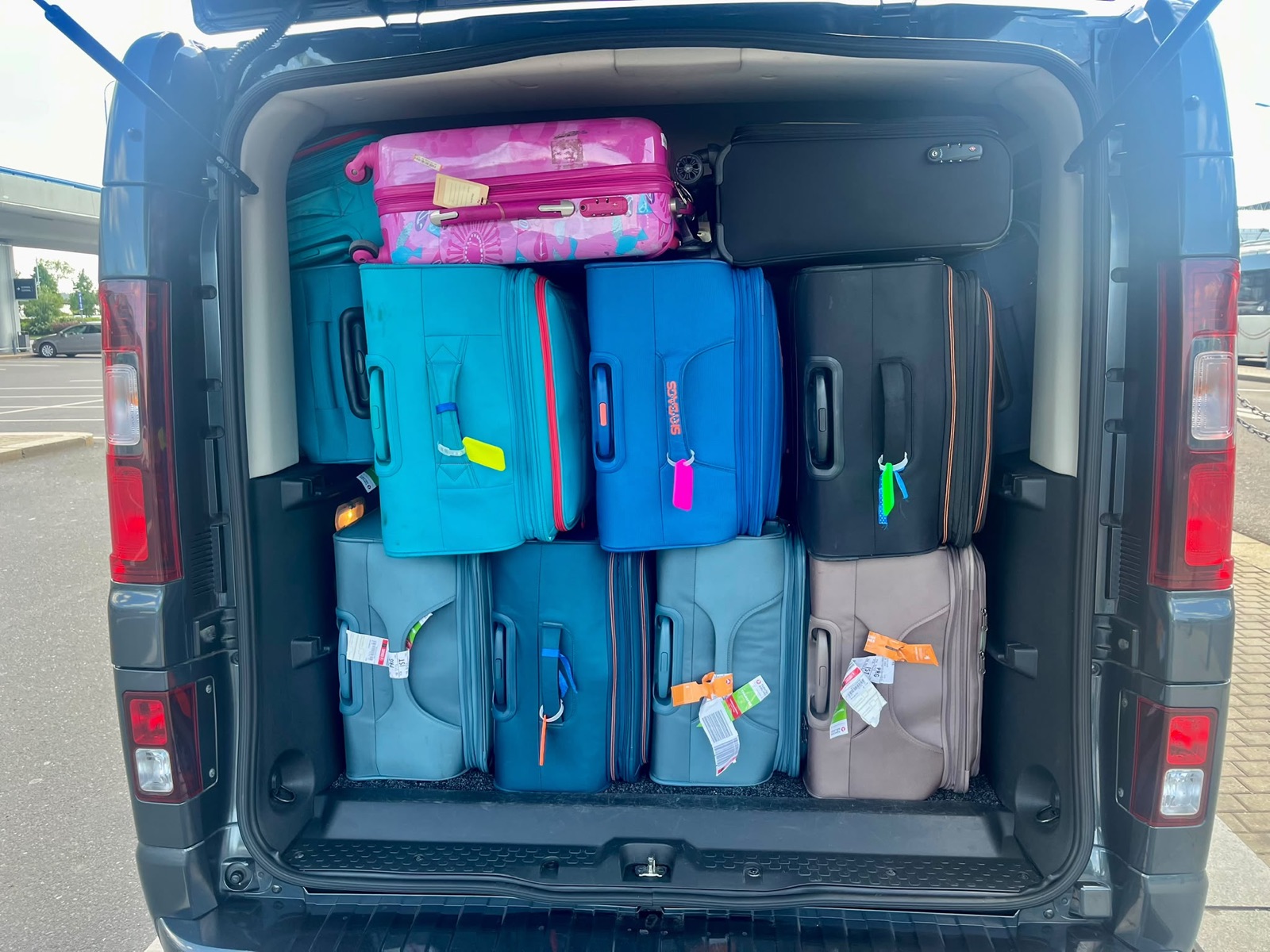 Suitcases arranged inside the rear luggage area of a van